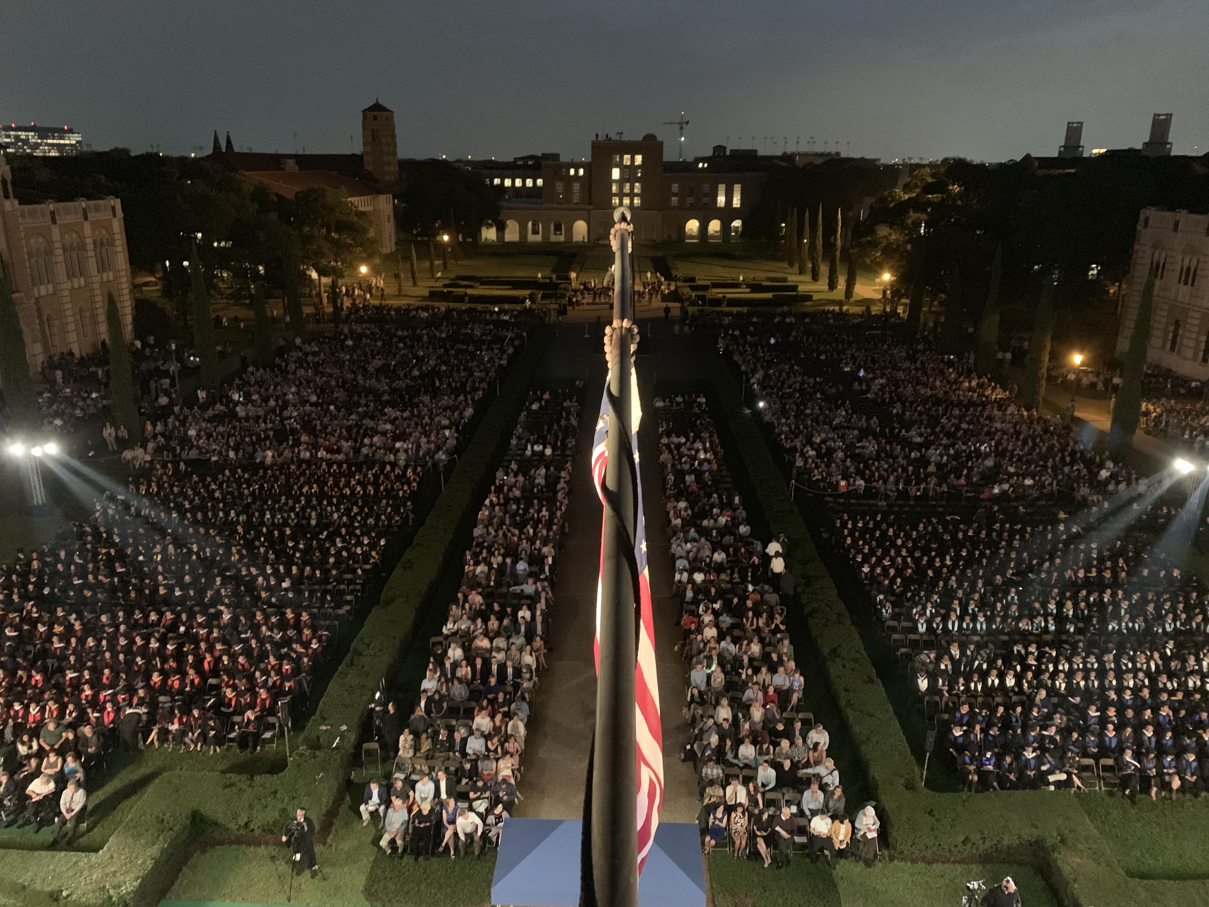 Aerial view of a Rice University commencement at twilight, thousands of guests seated in the academic quad