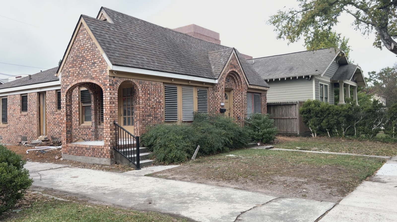 Brick cottage mid-renovation, with unfinished trim and a torn-up front yard